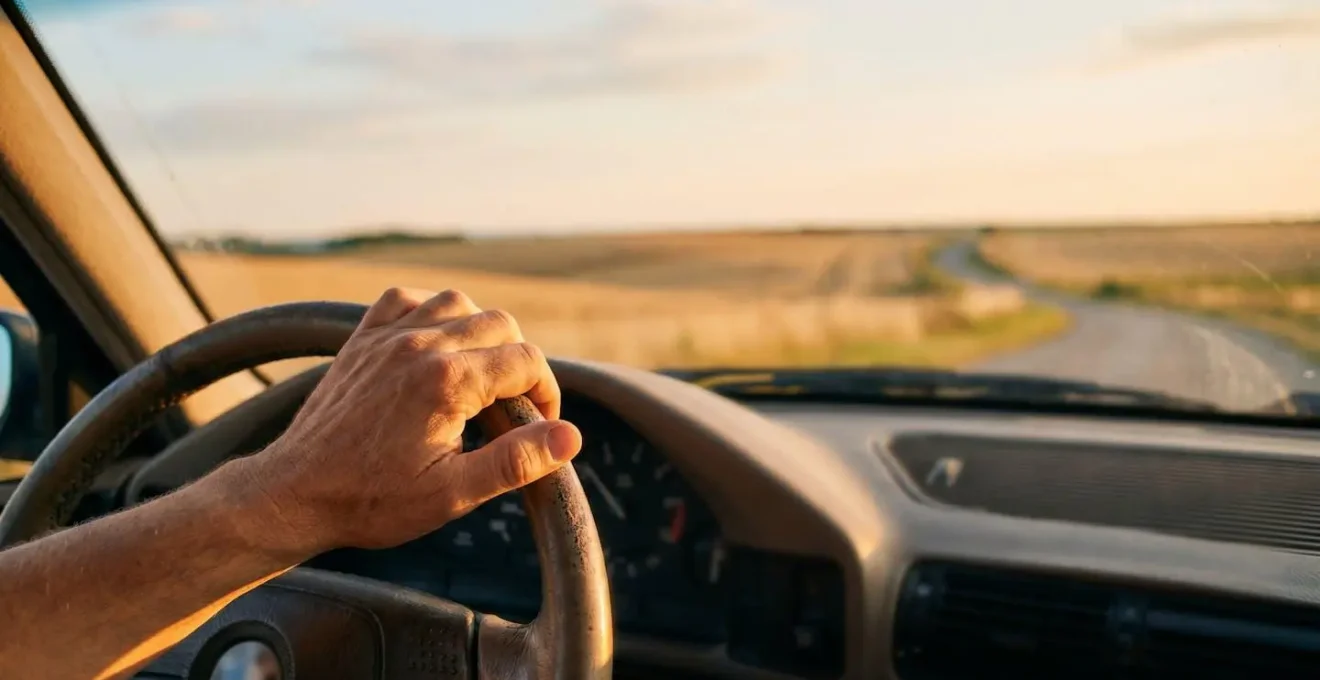 Conducteur serein sur une route de campagne française au lever du jour, symbole des automatismes d'éco-conduite