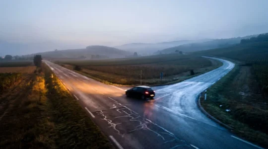 Illustration conceptuelle d'une route qui se divise, symbolisant le choix financier entre motorisation hybride, thermique et électrique en France