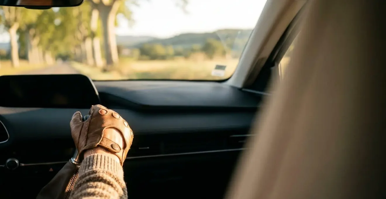 Main du conducteur posée avec douceur sur le levier de vitesses d'une voiture, dans une ambiance de conduite sereine en France